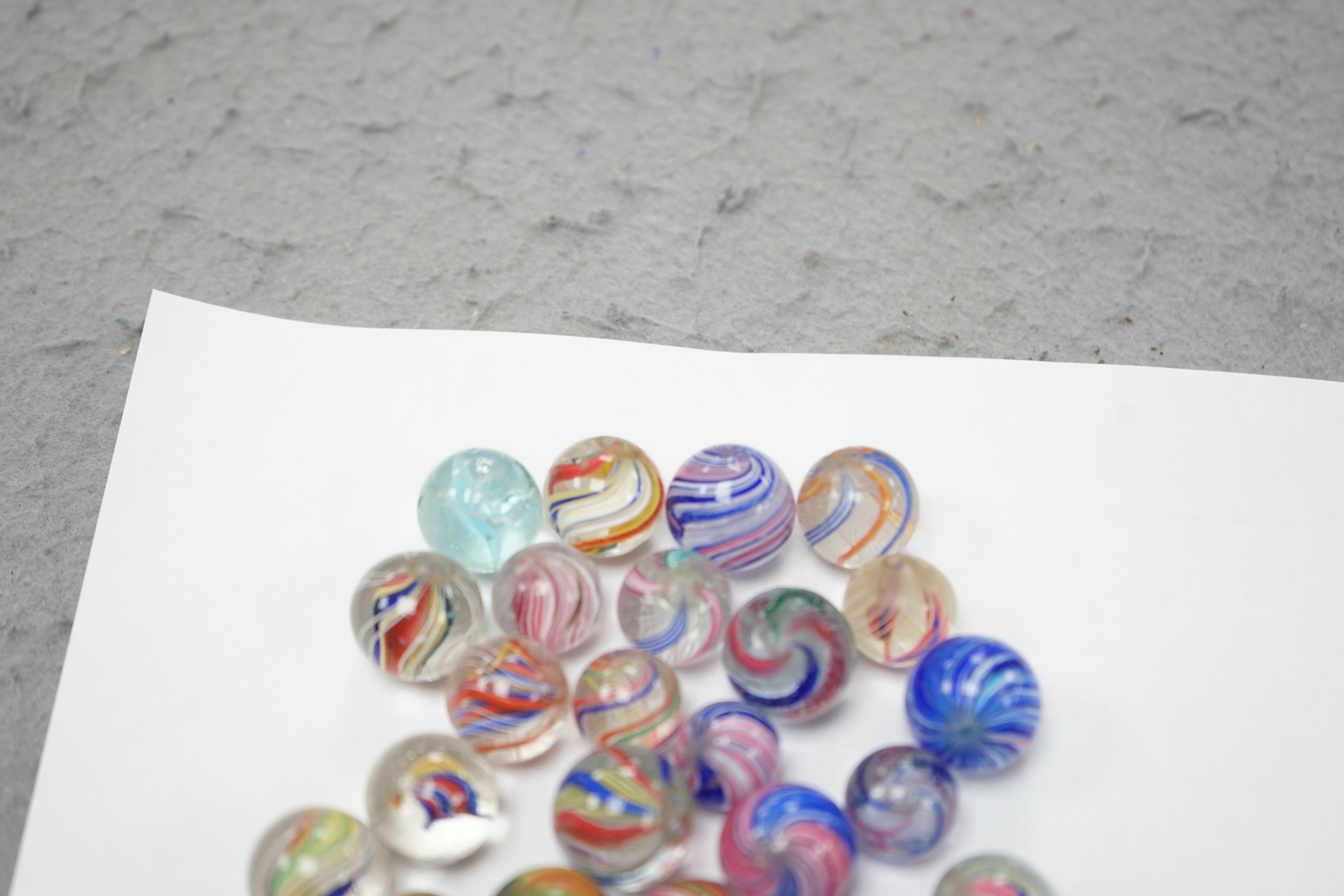 A mahogany solitaire board with a collection of latticino and marbled glass marbles
